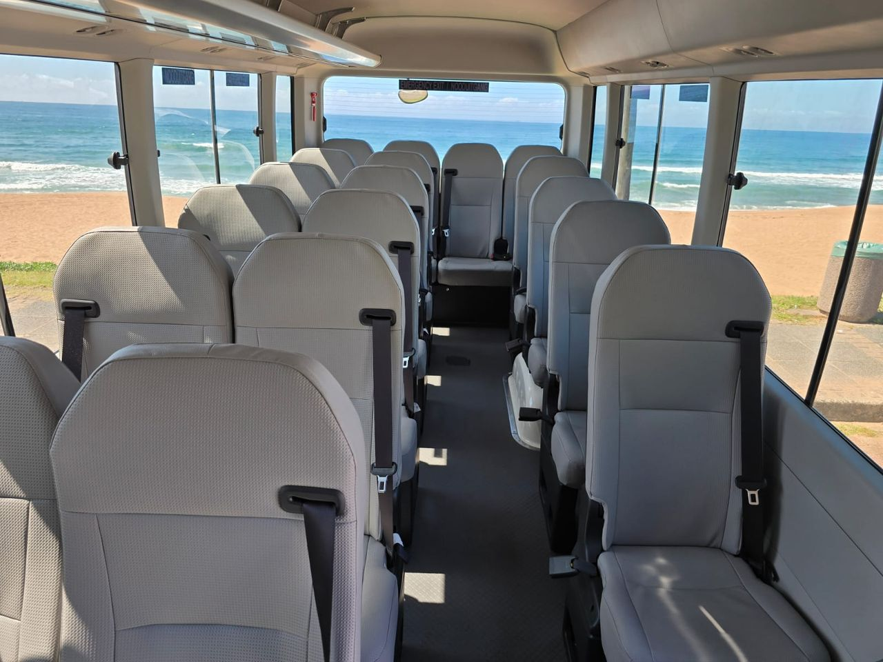 Comfortable seating inside the Toyota Coaster with ocean views