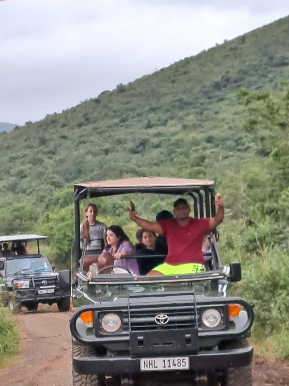 Guests on an open game drive vehicle in the KZN hills